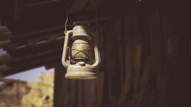 Antique lantern surrounded by rustic wood and shadows. Weathered lantern nestled within timber structures overlooking deep canyon and dim atmosphere
