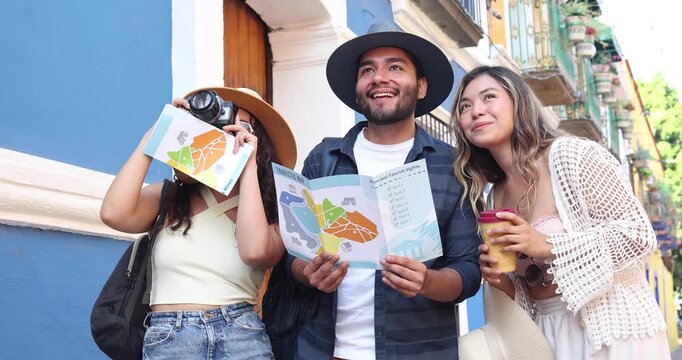 portrait of young latin friends traveling holding a tourist map in Mexico Latin America, hispanic people tourist in colonial city 