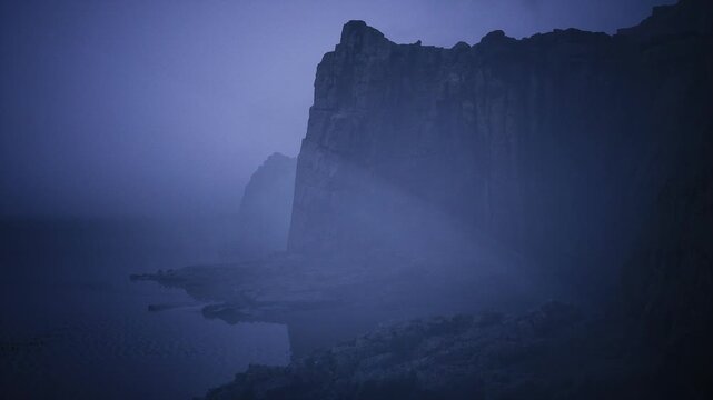 Monolithic cliff silhouette at blue hour, towering rock mass outlined against muted sky, deep shadowed faces and quiet sea below, majestic and brooding coastal
