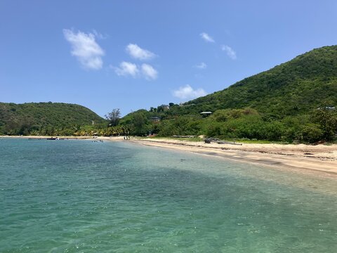 Peaceful tropical beach with turquoise water, sandy shore and green hills in St Kitts and Nevis