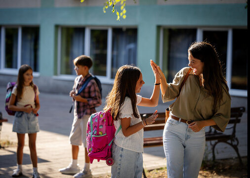 Children interact with adults outside a school