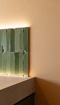Vertical photo of handmade green ceramic tiles on a wall. Modern interior design with rustic backsplash and architectural lighting. Copy space on beige wall