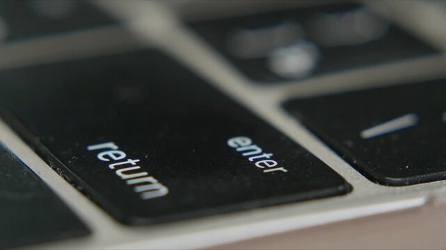 Close up of black and silver keyboard showing enter and return keys for typing