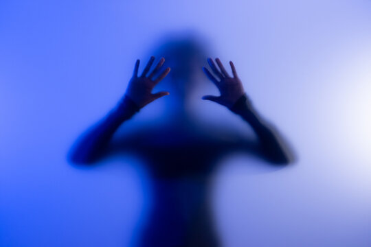 Woman silhouette behind frosted glass. Concept of anonymity and privacy protection. 