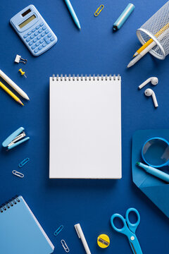 Back to school vertical flat lay with blank notebook and blue stationery for study and organization