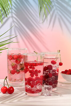 Modern still life with berry juice, raspberries, cherries, red currants, and ice on an elegant kitchen table, casting long, sharp shadows. The concept is a minimal detox diet, summer vitamin drinks