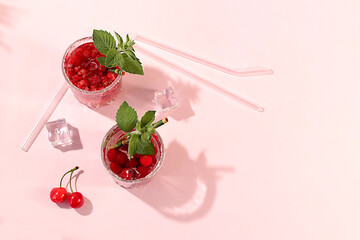 Modern still life with berry juice, raspberries, cherries, red currants, and ice on an elegant kitchen table, casting long, sharp shadows. The concept is a minimal detox diet, summer vitamin drinks © Светлана Балынь