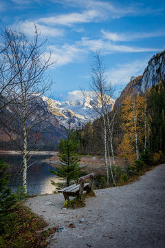 A wooden bench in front of a mountain lake. Gosau Lake (Upper Gosausee) location. Austria 