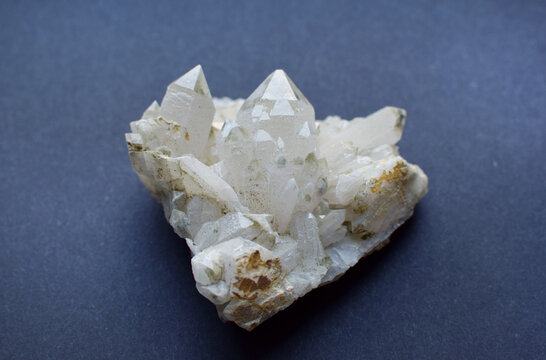 A druze of quartz rock crystal on a blue background. Semi-precious natural stones for magic and meditation. Healing crystals.