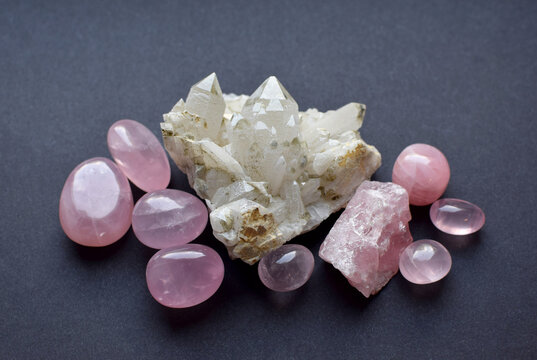 Rock crystal quartz druse and rose quartz crystals on a gray background. Semi-precious natural stones for magic and meditation. Healing crystals.