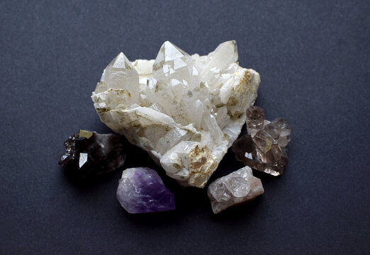 Rock crystal and smoky quartz druze on a gray background. Semi-precious natural stones for magic and meditation. Healing crystals.