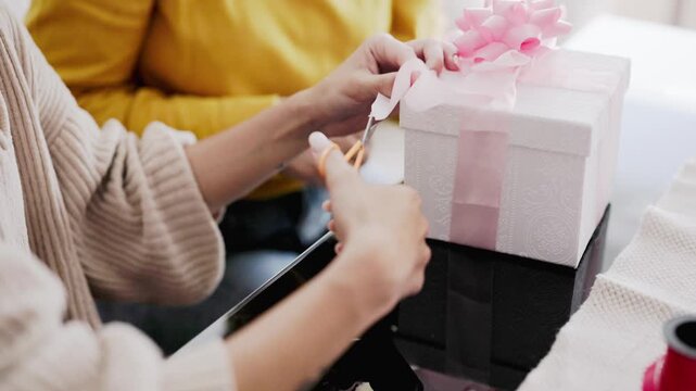 Hispanic mother and daughter decorating handmade gift together