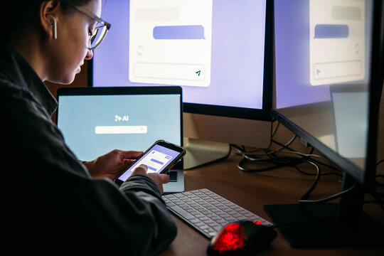 Young woman writing AI promt in a modern office.