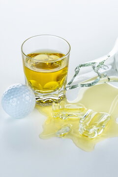 Bicchiere di Whisky con pallina da golf dopo una sconfitta a fine partita	