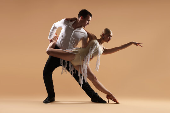 Couple of professional dancers on beige background
