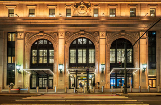 New York, NY - US - Jul 20, 2026 The illuminated facade of Moynihan Train Hall in New York City features grand classical arches, ornate stonework, glowing lanterns, and modern glass entrance canopies.