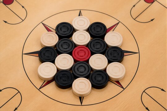 Carrom men arranged in circle on wooden carrom board
