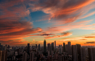 Obraz premium Wuhan CBD skyline illuminated by a dramatic fiery sunset. These brilliant burning clouds above towering skyscrapers symbolize a blazing, prosperous economy and the dawn of a dynamic financial future.