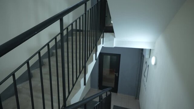 Interior view of multi level staircase with metal railings and clean white walls showing modern building architecture