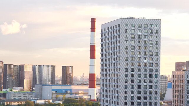 City landscape with high rise residential buildings and industrial chimney showing urban development and energy infrastructure
