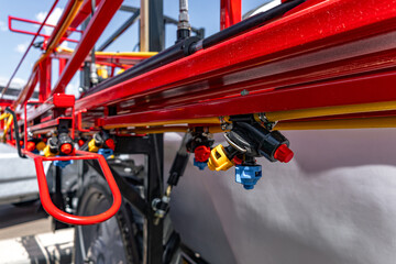 Naklejka premium Agricultural field sprayer nozzle body on boom for pesticide application. Modern crop protection machinery engineering component and farming transport equipment closeup details for cultivation.