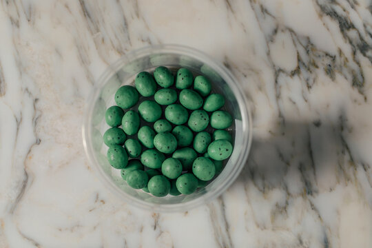 green mint malt ball candy on white marble table
