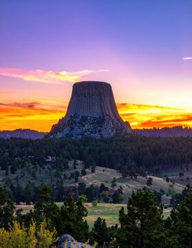Devils Tower National Monument at sunset with vibrant sky.