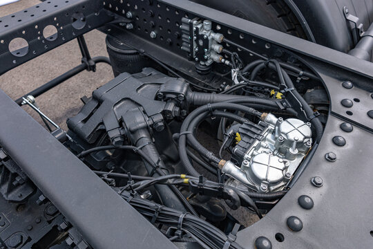Semi truck chassis EBS brake control valve valve module. Modern commercial heavy duty transport vehicle air pneumatic system component on frame with long haul tractor technical engineering details.