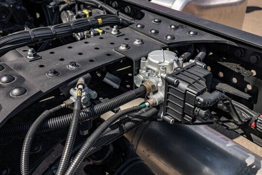 Semi truck chassis EBS brake control valve valve module. Modern commercial heavy duty transport vehicle air pneumatic system component on frame with long haul tractor technical engineering details.