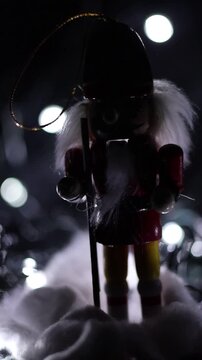 Una toma de cerca de un cascanueces o soldadito con luz en un fondo negro. Video vertical 