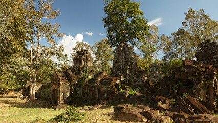 Obraz premium Old Khmer architecture and collapsed stone structures on a sunny day. Banteay Prei Temple, Cambodia