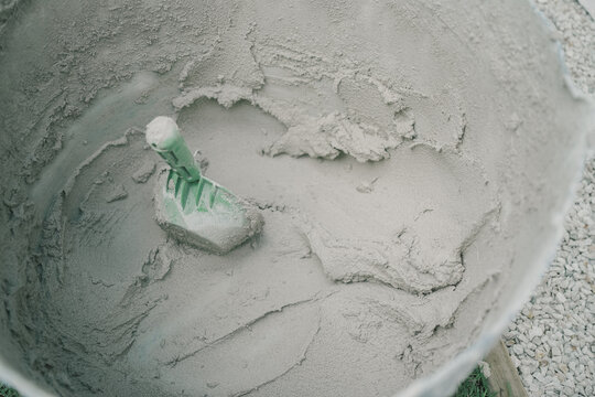 concrete, mortar, bucket, trowel, construction, mixing, cement being prepared for masonry work on a building site. This high-angle close-up shows wet mixture for renovation.