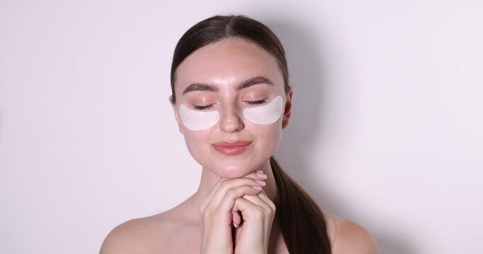 Beautiful woman with eye patches on white background