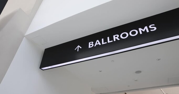 A straightforward B-roll shot featuring a clearly marked "Ballroom" directional sign, providing wayfinding and navigation for attendees inside a large convention center or event venue.
