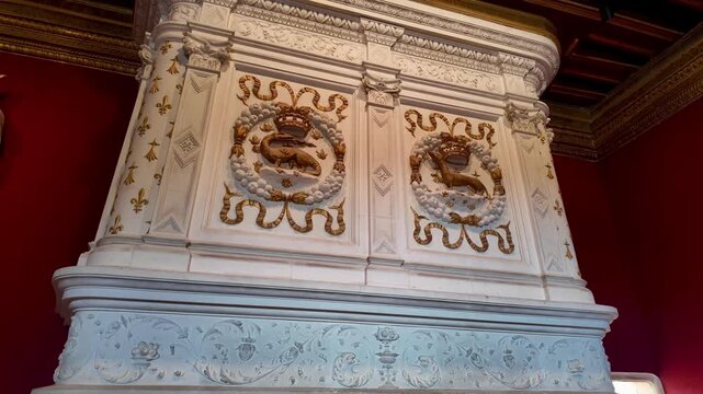 Close-up of the richly decorated Renaissance fireplace at Ch&acirc;teau de Chenonceau, featuring ornate sculpted reliefs, royal heraldic emblems, gilded details, and elegant stone carvings.