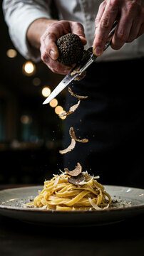 Black truffle being shaved over pasta dish in upscale dining setting