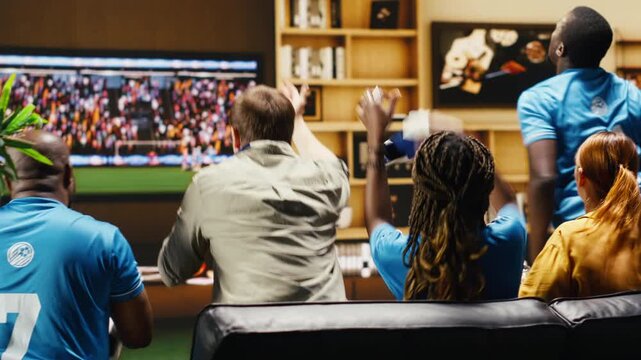 Upset football supporters watch match on television, cursing players after close chance as soccer fans show annoyed body language after receiving a goal.