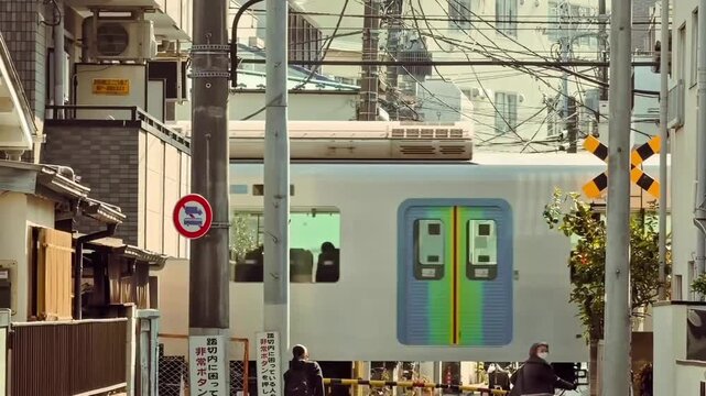 Commuter Train Passing Through Urban Japanese Railway Crossing