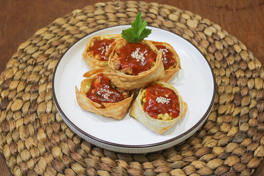 Crispy Fried Dumplings With Chili Sauce On Woven Placemat