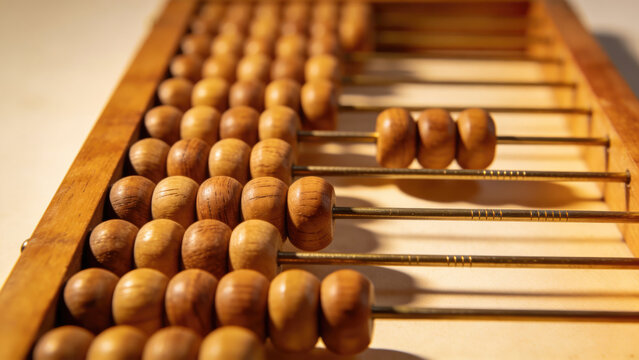 Vintage wooden abacus with beads on rods, close-up, antique calculator for math and counting