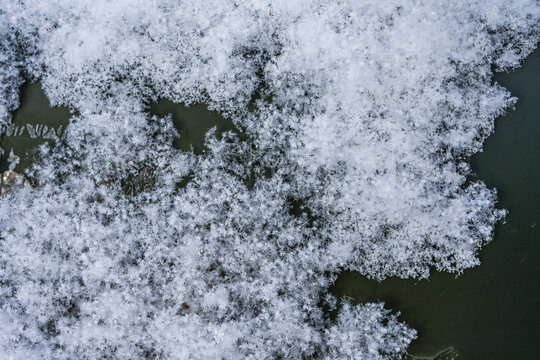 Snowflakes forming on the surface of the car. When extremely cold water droplets freeze directly around microscopic particles like dust or pollen in subfreezing clouds.
