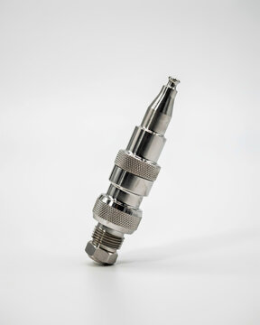 Close-up of a metallic industrial connector with knurled grip and threaded end steel chrome