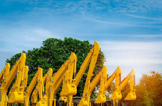 Hydraulic excavators lined up in equipment yard for construction projects, heavy machinery fleet management, infrastructure development, civil engineering and industrial equipment rental business.