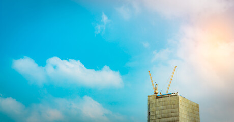 Modern high rise building under construction with tower cranes. Urban development, engineering progress and future real estate growth. Architecture, infrastructure expansion, property investment. © Fahroni