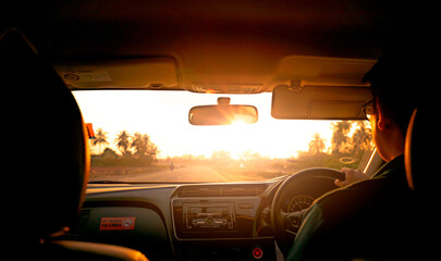Fototapeta premium Driving along an open countryside road during golden hour viewed from inside a modern vehicle, capturing a peaceful travel experience, transportation lifestyle and freedom of road trip adventure.