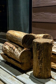 Close-up of timber logs on a deck with warm spot lighting, vertical view