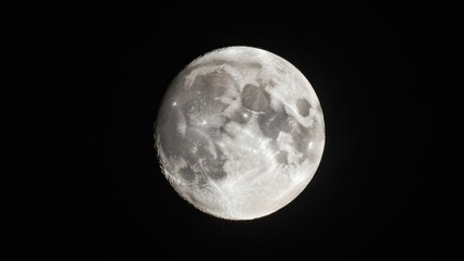 Obraz premium Full moon glowing brightly in the dark night sky showing detailed craters and lunar surface texture against a pitch black celestial background with natural cosmic light