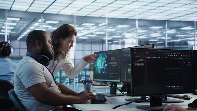 Team leader teaching IT specialist to monitor AI supercomputers from a secondary camera angle while highlighting data protection, network security and infrastructure risk.