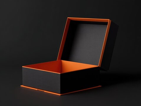 An open black box with orange inner lining and trim, slightly angled against a dark background, revealing its empty interior