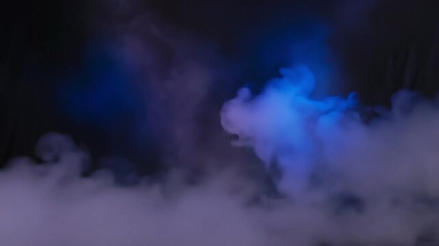 Abstract blue and purple smoke floating in a dark studio background loop video clip